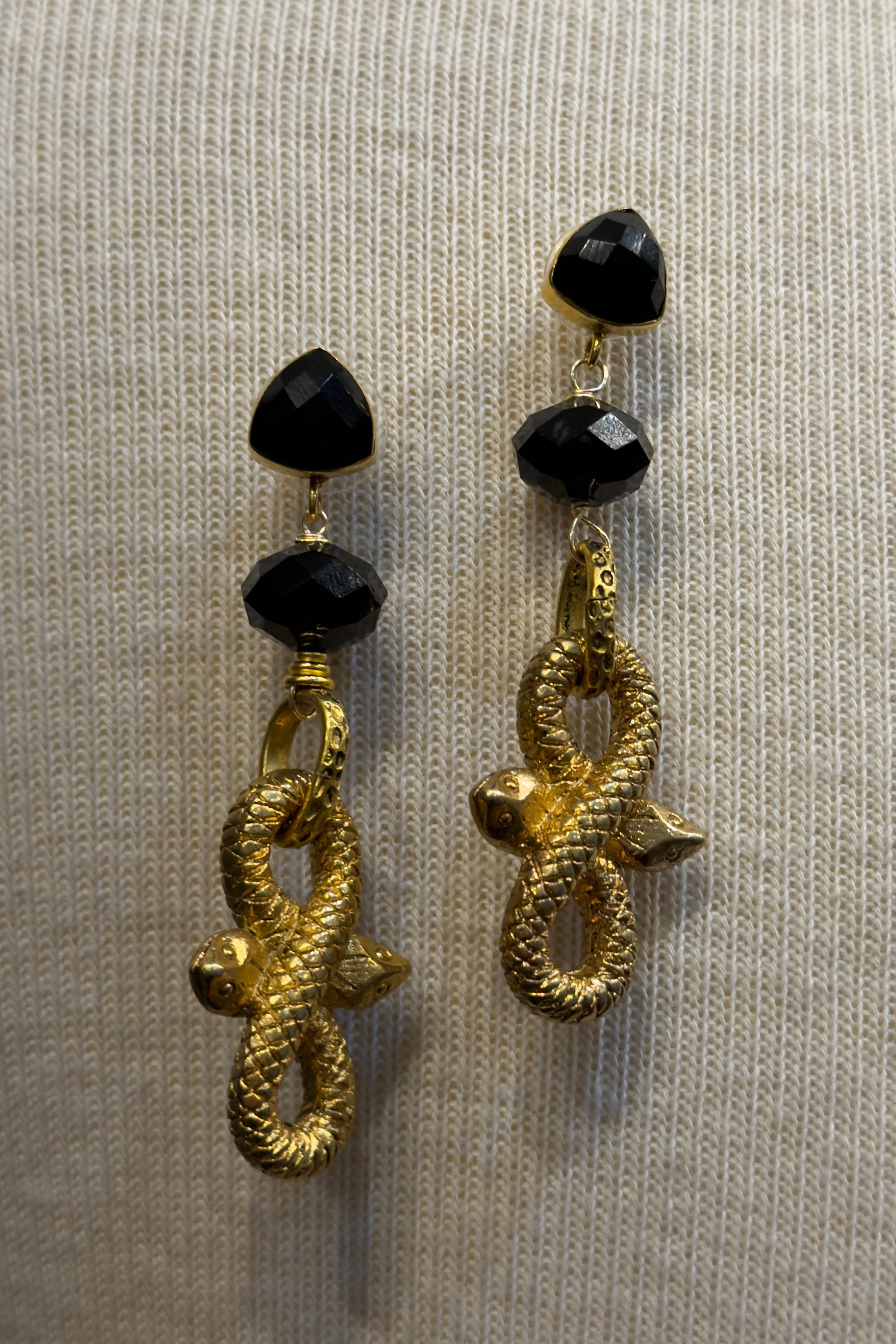 Gold snake-shaped earrings with black beads